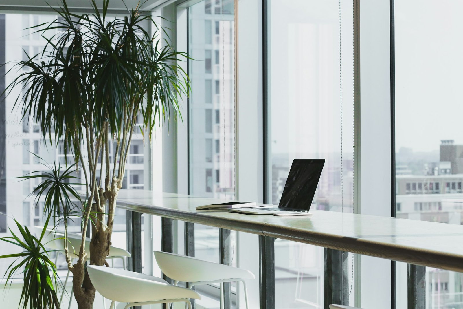 Arbeitsplatz mit Laptop am Fenster — Handwerker wickeln Aufträge digital ab
